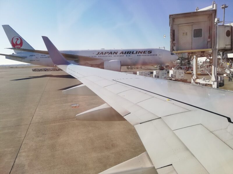 JAL機の機内窓から新千歳空港内を眺める